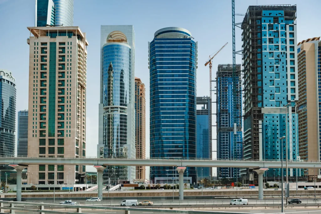 Modern glass skyscrapers and highway in Dubai, representing top accommodation areas for Dubai Design Week 2026.