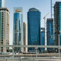 Modern glass skyscrapers and highway in Dubai, representing top accommodation areas for Dubai Design Week 2026.