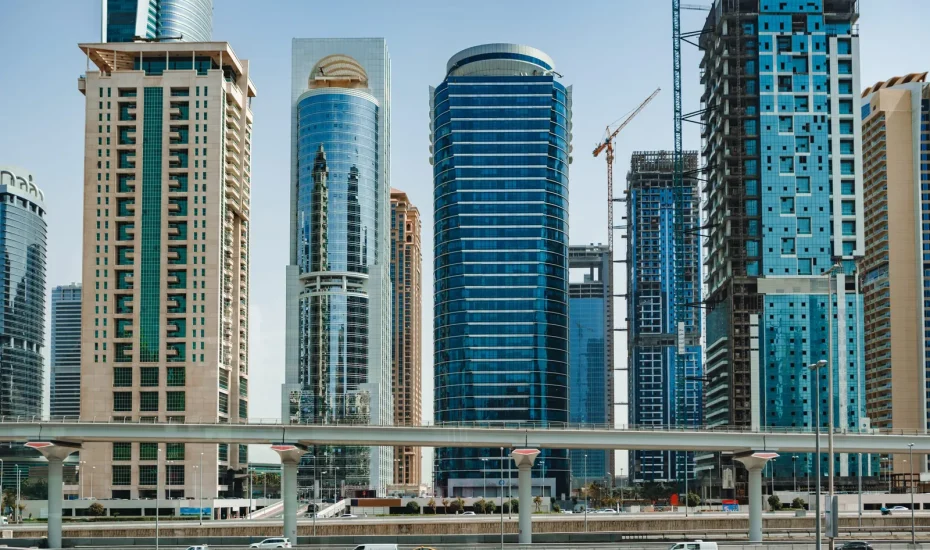 Modern glass skyscrapers and highway in Dubai, representing top accommodation areas for Dubai Design Week 2026.